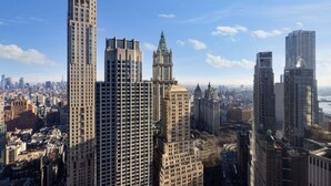 Un paisaje urbano con rascacielos y edificios destacados, incluyendo un rascacielos alto y un edificio histórico con una torre de reloj.