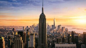 Une vue urbaine mettant en valeur un gratte-ciel imposant, vraisemblablement un hôtel, caractérisé par un design moderne et surmonté d’une flèche.