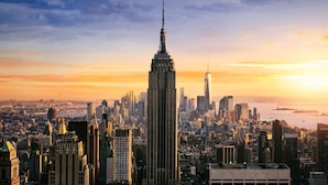 A cityscape with a prominent skyscraper, likely a hotel, featuring a modern design with a spire. - Double Deluxe | Times Square l City View (New York)