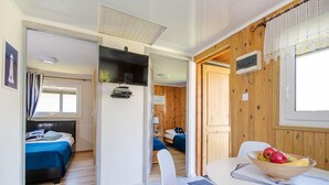 A room with a bed, a desk with a bowl of fruit, and a chair with an orange cushion. - Comfortable Holiday Homes, Jacuzzi, Summer Pool (Postomino)