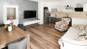Eine moderne Küche mit Flachbildfernseher, Kühlschrank und Mikrowelle.