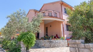 A two-story building with a stone facade and a covered entrance. - Apartman FLORIS with AC and WIFI (Punat)