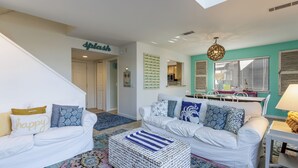 A living room with two white sofas, a colorful rug, and a striped ottoman. - 7 Ocean Gate Villas: 2 Bedroom South Forest Beach Villa (Hilton Head Island)