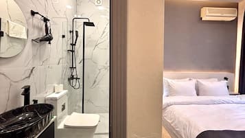 Deluxe Double Room, Garden View | Bathroom | Hair dryer, slippers, towels, soap