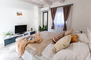 A modern bedroom with a bed, TV, and plants. - Romantic hideaway, private house with jacuzzi, sauna, free parking, AC, grill (Balatonalmádi)
