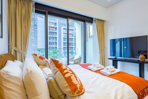Una camera d'albergo con un letto grande, una TV e vista sulla città.
