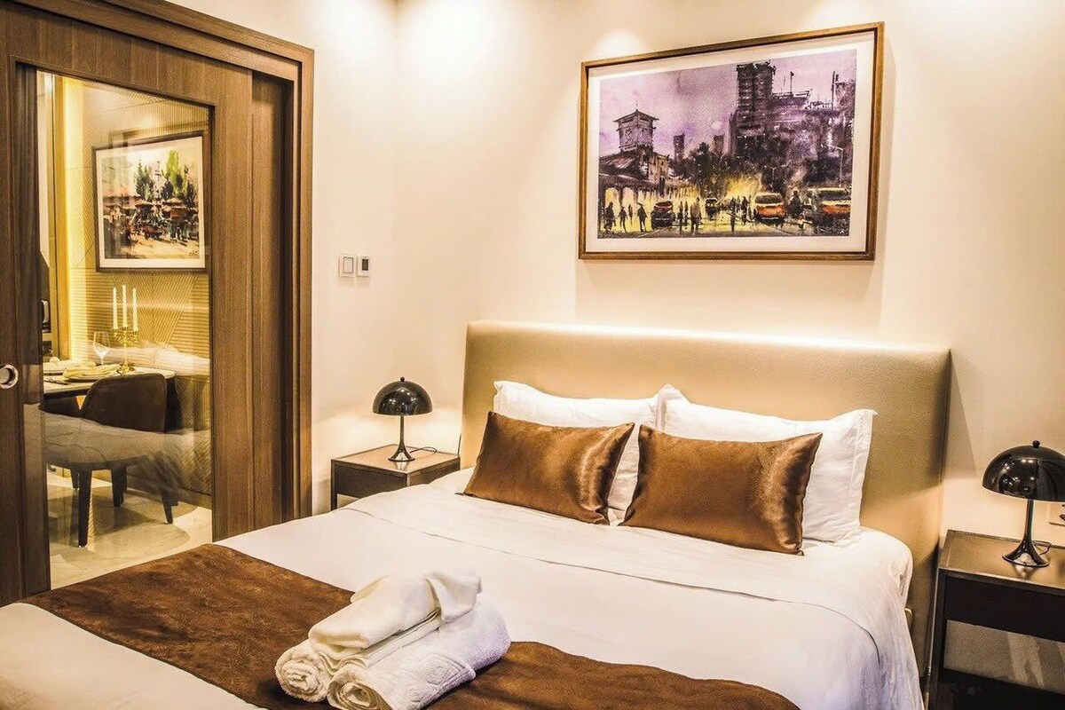 Ein Hotelzimmer mit einem großen Bett, einem Bild an der Wand und einem Schreibtisch mit Stuhl.