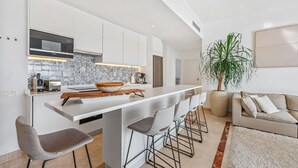 A modern kitchen with white cabinetry, a built-in microwave, and a tiled backsplash. - Apartment 'Paraiso Pueblo' with Sea View, Wi-Fi and Air Conditioning (Benahavís)