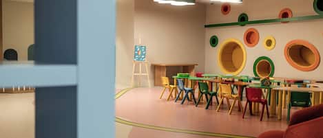 Un salón infantil con muebles coloridos y un cuadro en la pared.