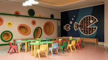 Une salle de jeux pour enfants avec des meubles colorés et des décorations murales ludiques.