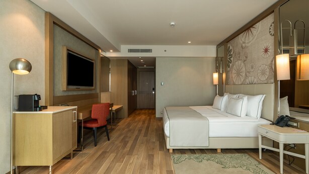 A hotel room with a bed, desk, chair, and a television. - Sinnada Resort & Thermaland (Afyonkarahisar)