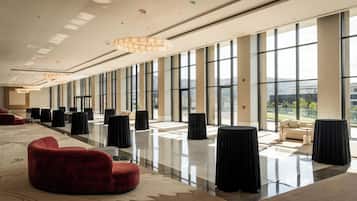 Un hall espacioso con techos altos, amplias ventanas y mobiliario moderno.