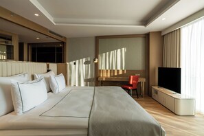 A hotel room with a large bed, a desk, a chair, a television, and a wardrobe. - Sinnada Resort & Thermaland (Afyonkarahisar)