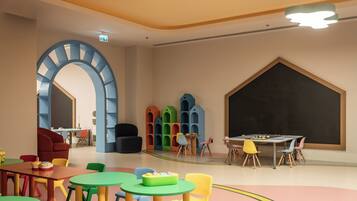Un salón infantil con muebles coloridos y una pared con pizarra.
