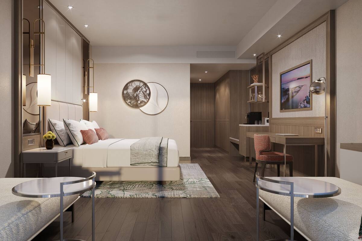 Une chambre d’hôtel moderne équipée d’un lit, de tables de chevet, d’un bureau et d’une chaise.