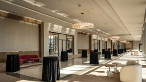A spacious hotel lobby with a red sofa, black tables, and a chandelier. - Sinnada Resort & Thermaland (Afyonkarahisar)