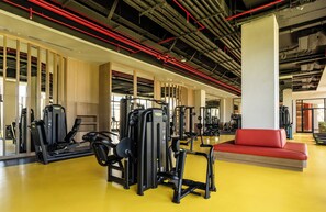 A gym with exercise equipment, a red couch, and a yellow floor. - Sinnada Resort & Thermaland (Merkez / Afyonkarahisar)