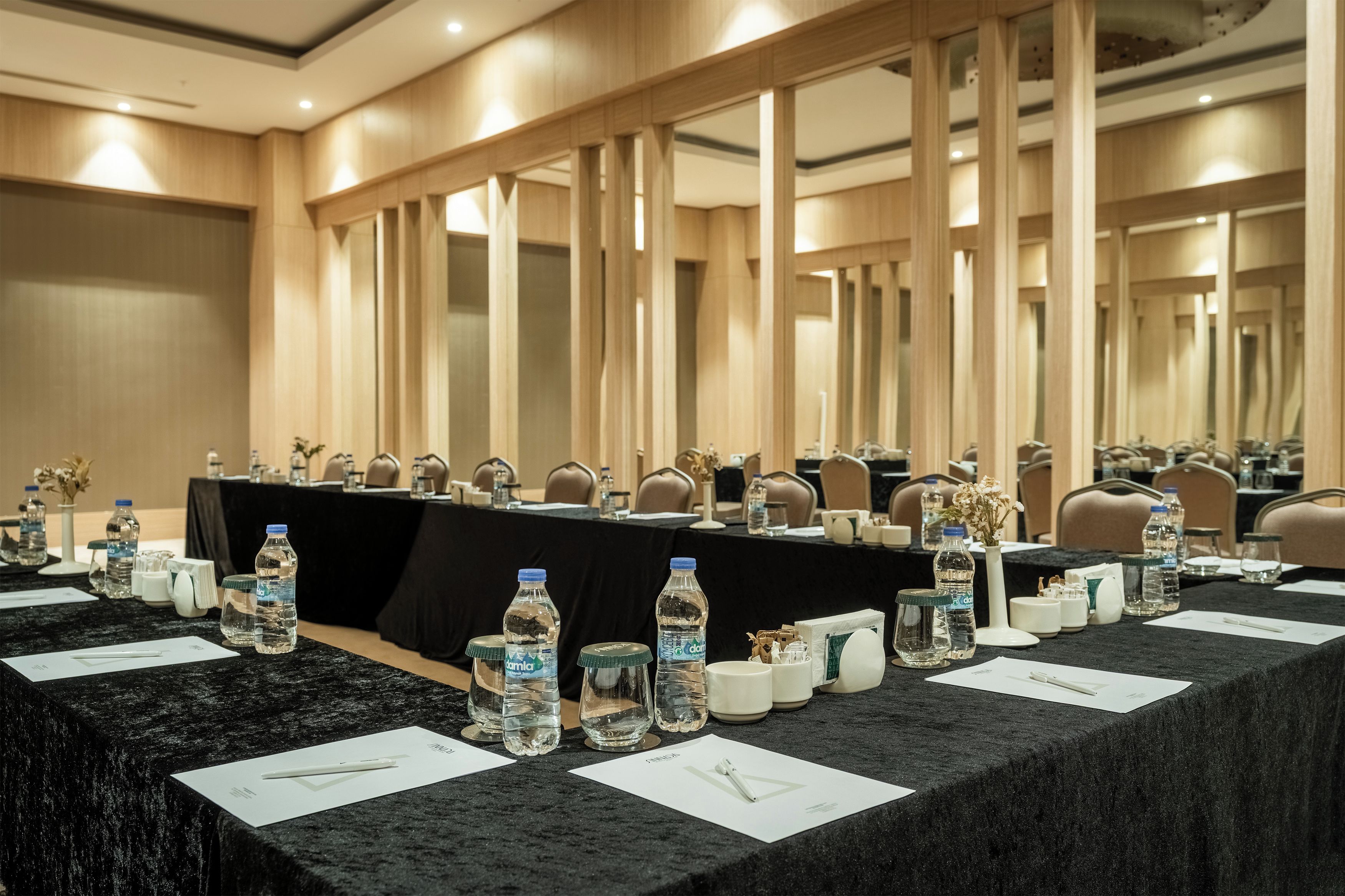 A conference room with a long table, chairs, water bottles, and nameplates.