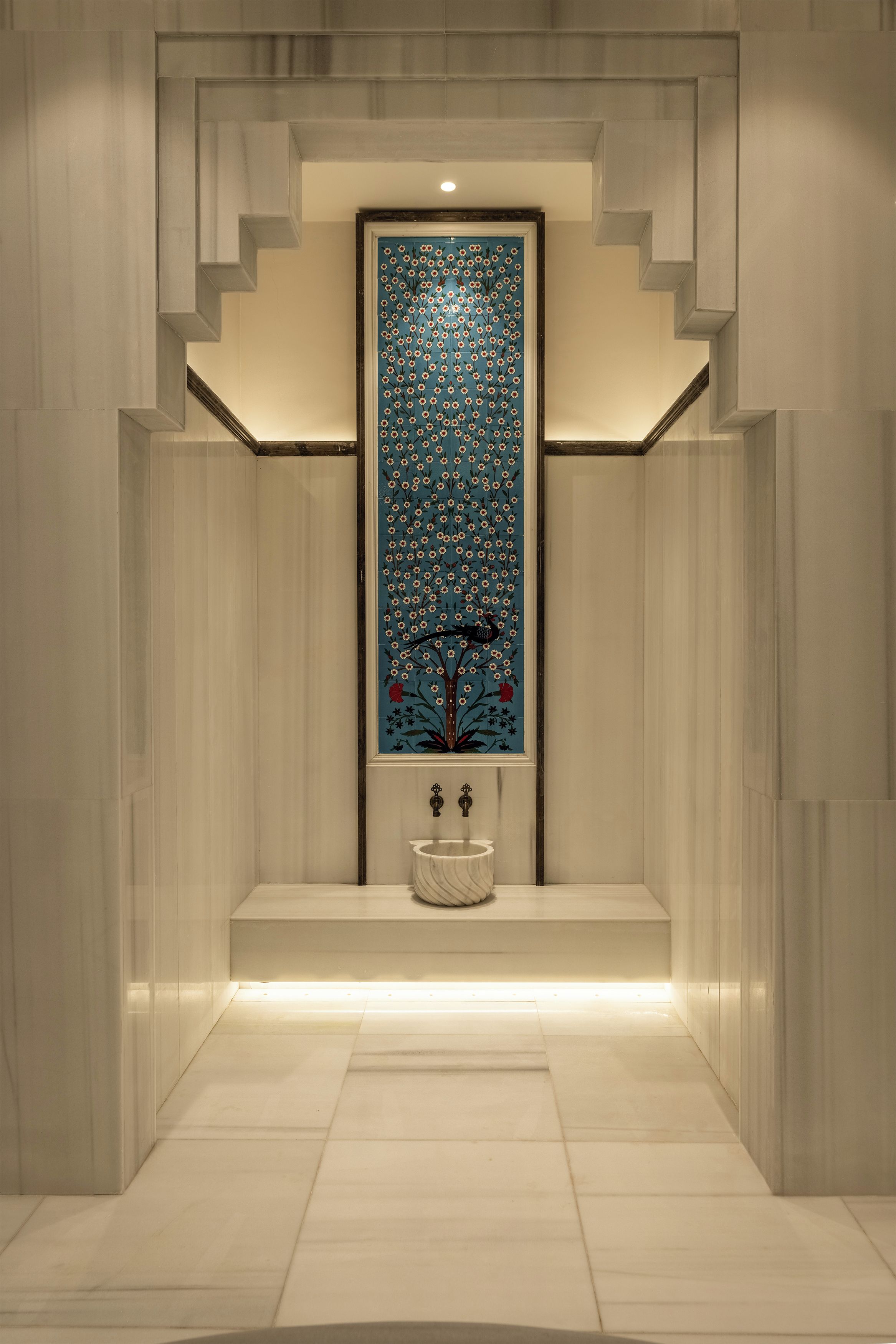 A modern bathroom with a marble floor, a sink, and a decorative wall panel.