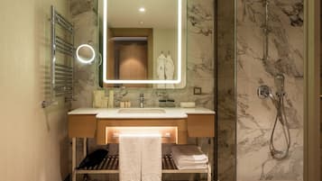 A modern bathroom with a vanity, a mirror, a towel rack, and a shower area.
