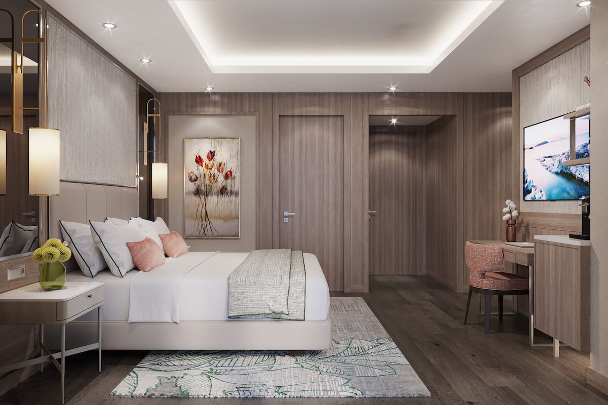 Une chambre moderne comprenant un lit, une table de chevet, une lampe, une œuvre d’art et un téléviseur.