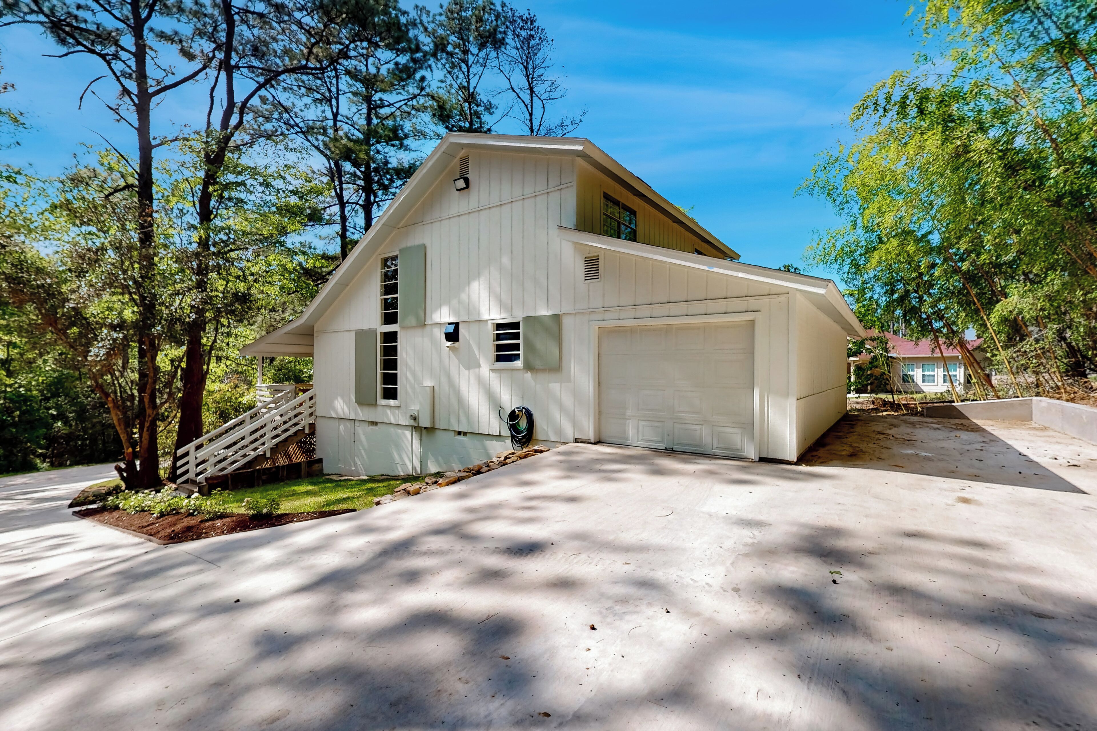A single-story house with a garage, a front porch, and a staircase leading to a second level.