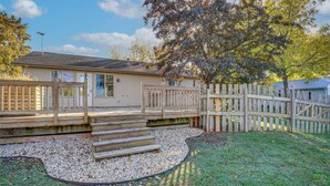 A single-story house with a wooden deck, a gravel pathway, and a fenced yard. - Angler's Retreat 1 Block to Lake Winneconne (Winneconne)