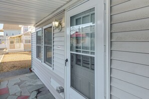 A house with a covered porch, a screened door, and a small mailbox. - Walk to Public Beach Access! Breezy Hampton Condo (Hampton)