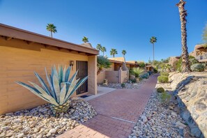 A pathway leading to a building with a palm tree and agave plant in the foreground. - Hike & Explore Dtwn Tucson! Relaxing Solo Escape (Tucson)