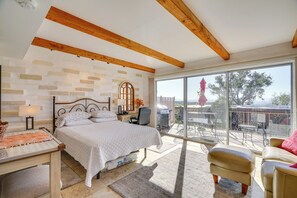 A bedroom with a bed, a desk, a chair, a balcony with a view of the outdoors. - Hike & Explore Dtwn Tucson! Relaxing Solo Escape (Tucson)