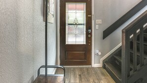A wooden door with a glass panel, a metal handrail, and a staircase with wooden steps. - Golf, Boat, Swim! Point Venture Retreat w/ Deck (Leander)