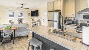 A modern kitchen with a large island, stainless steel appliances, and a seating area with a table and chairs. - Walk to Marina: Waterfront South Holston Lake Home (Bristol)