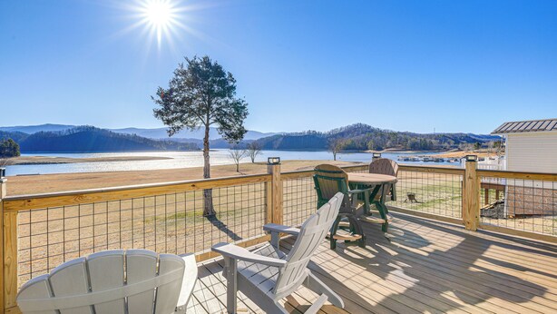 A deck with Adirondack chairs overlooking a lake and mountains. - Walk to Marina: Waterfront South Holston Lake Home (Bristol)