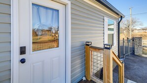 A white door with a window, a wooden railing, and a stone wall. - Walk to Marina: Waterfront South Holston Lake Home (Bristol)