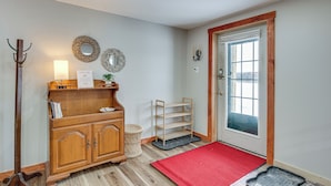 A wooden cabinet with a mirror, a welcome sign, and a red doormat at the entrance. - Explore the Northeast Kingdom! Home w/ Deck (Norton)