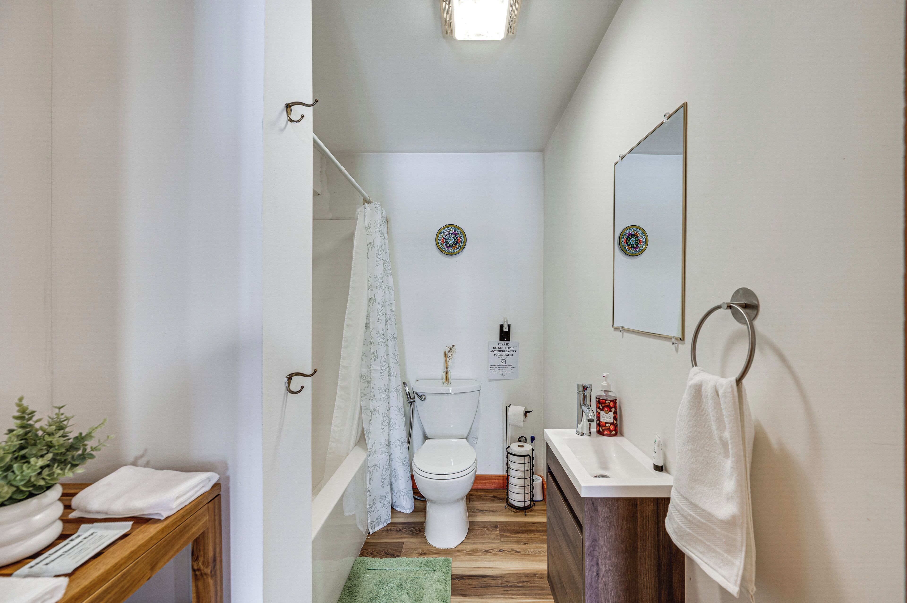 A compact bathroom with a toilet, sink, and shower area.