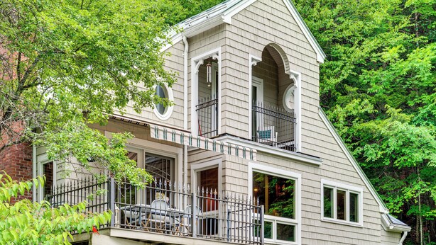 A two-story house with a balcony, large windows, and a brick foundation. - Gorgeous Fall Foliage, Adjacent to Woodstock (Strafford)