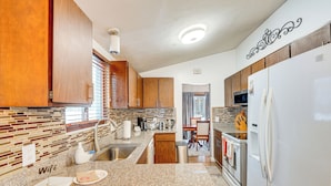 A kitchen with granite countertops, wooden cabinets, a stainless steel refrigerator, and a microwave. - Close to Hospitals & Downtown: Cleveland Home (North Olmsted)