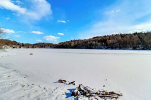 A frozen lake with trees in the background and a clear sky.
