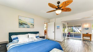A bedroom with a large bed, a ceiling fan, and a view of the outside. - Snead Island Getaway! Steps to Bay & Emerson Point (Palmetto)