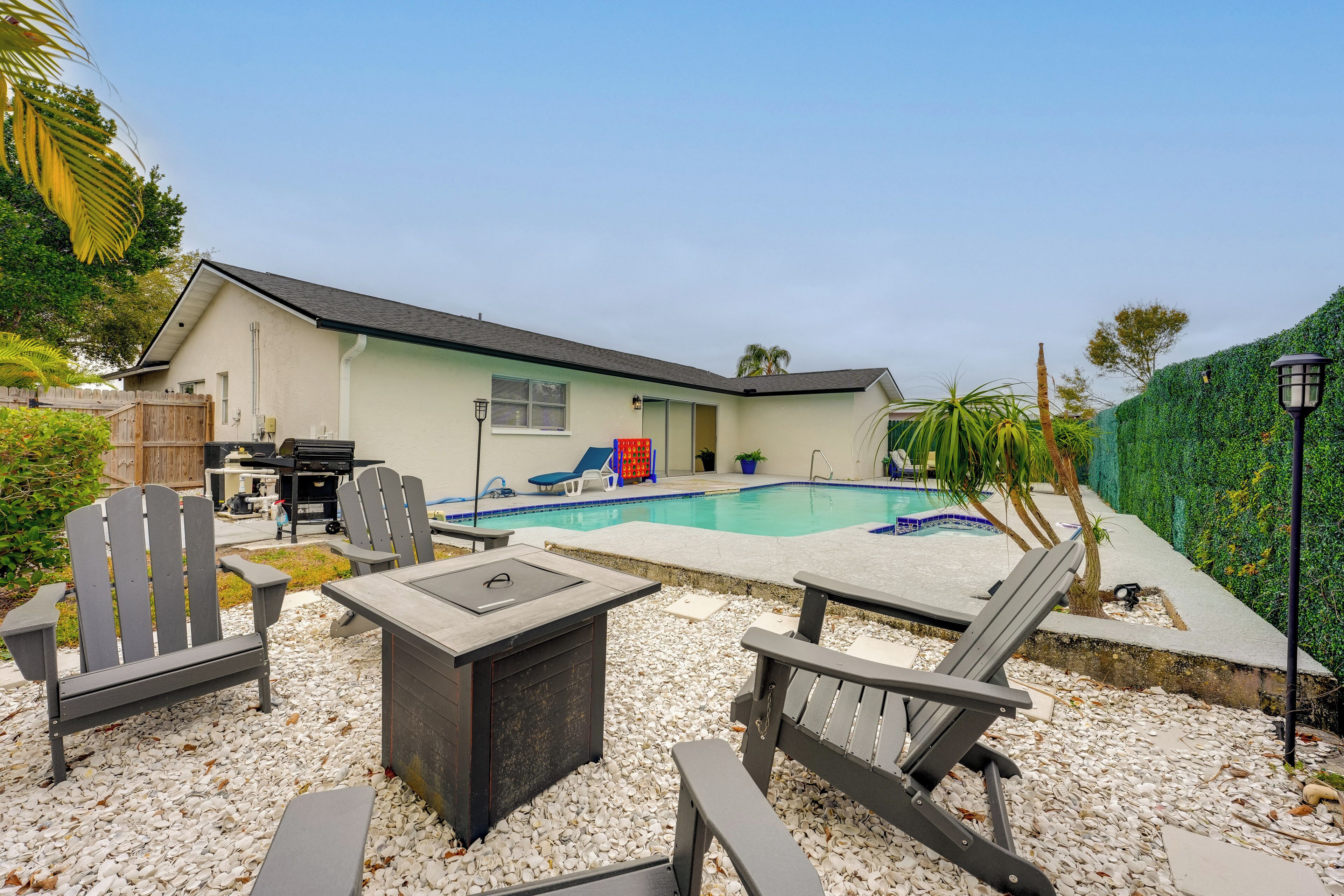 Un jardin avec une piscine, un espace salon extérieur et une maison.