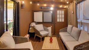 Una habitación acogedora con muebles de mimbre, una mesa de madera y un ventilador de techo.