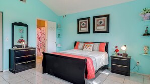 A bedroom with a bed, bedside tables, a dresser, and a mirror.