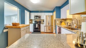Una cocina moderna con encimeras de granito, electrodomésticos de acero inoxidable y paredes azules.