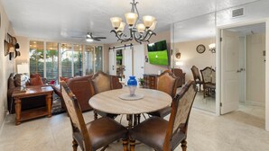 A dining area with a round table, chairs, and a chandelier. - Walk to Old Town & Fashion Square, Condo w/ Patio! (Scottsdale)
