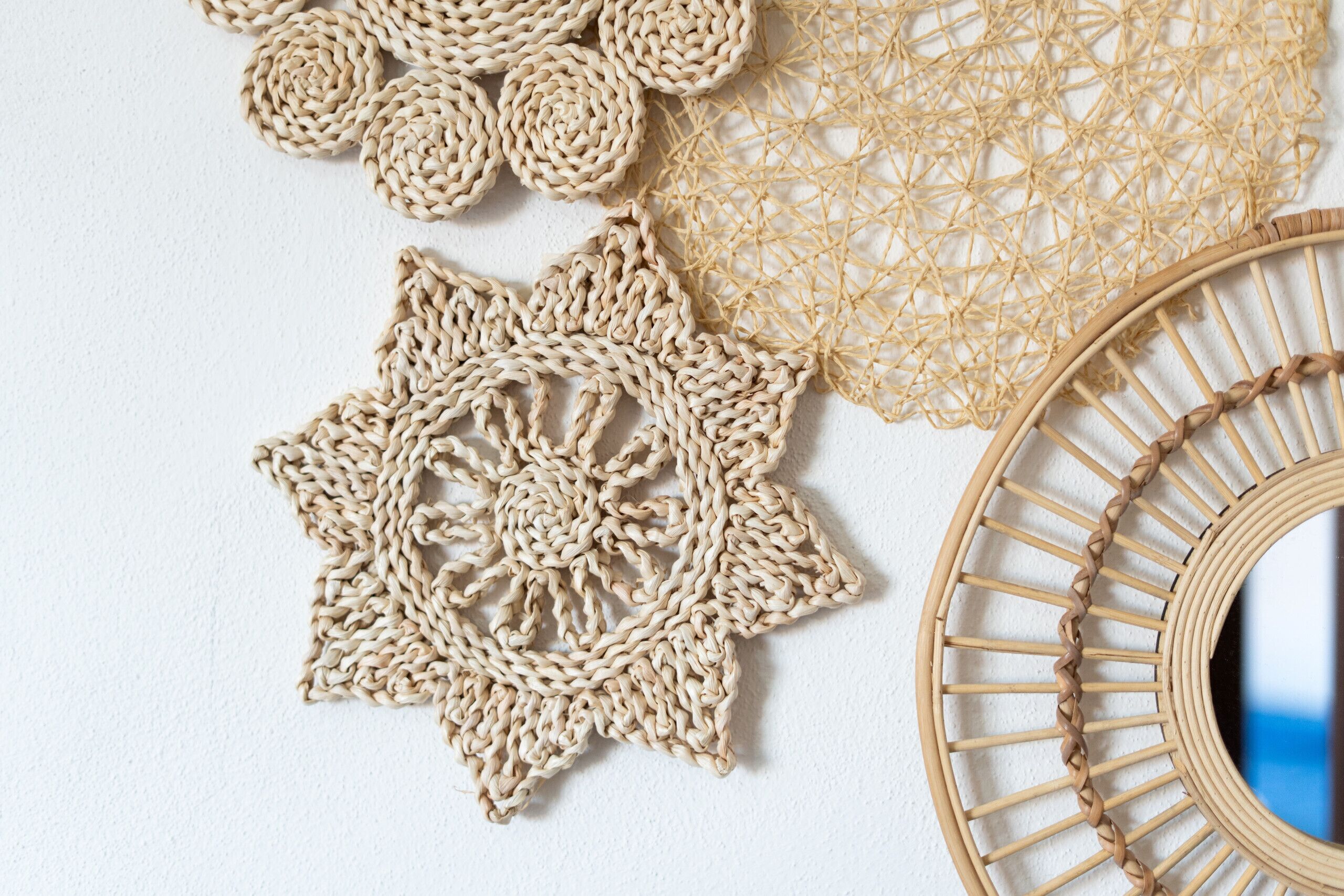 A close-up of various woven decorative items, including a star-shaped pattern and a circular woven frame.