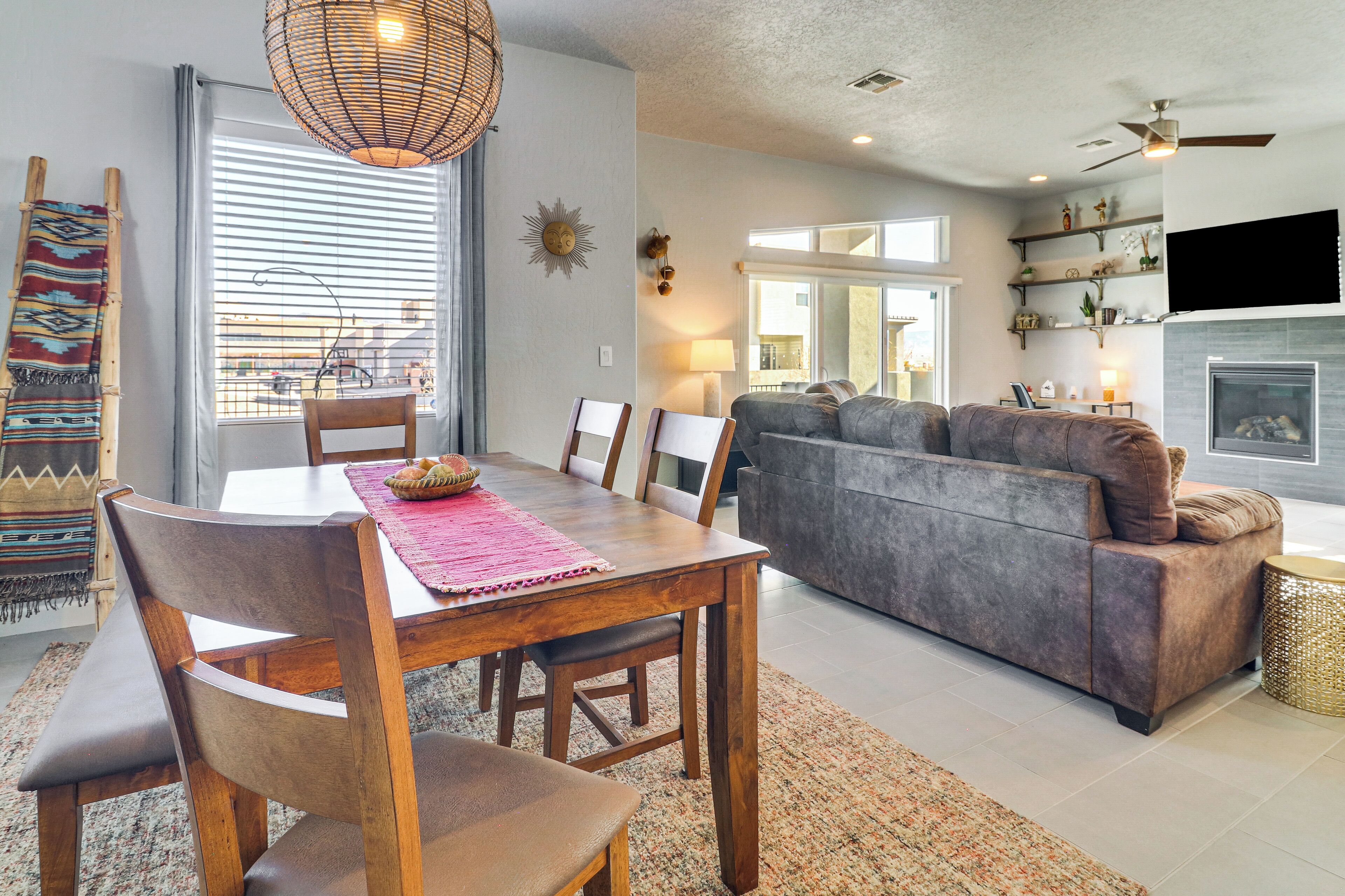 A modern living room with a sofa, dining table, chairs, and a fireplace.