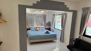 Een moderne slaapkamer met een bed, een bank en een raam met gordijnen.