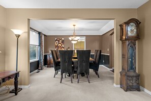 A dining room with a table and chairs, a chandelier, and a grandfather clock. - New Listing! Pinery Lakeshore Retreat | Near Park (Parker)