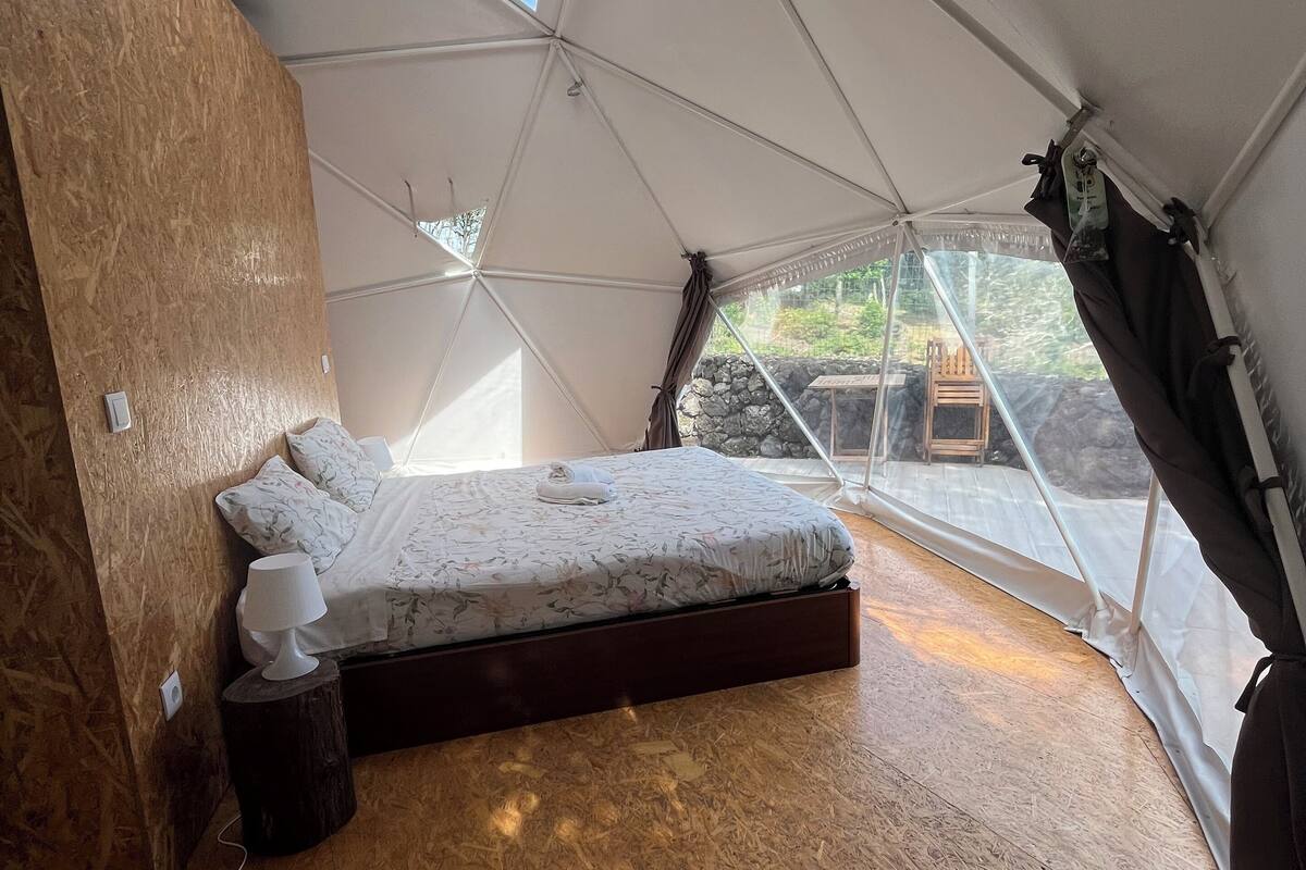 Un dormitorio con una cama, una mesita de noche y una lámpara.